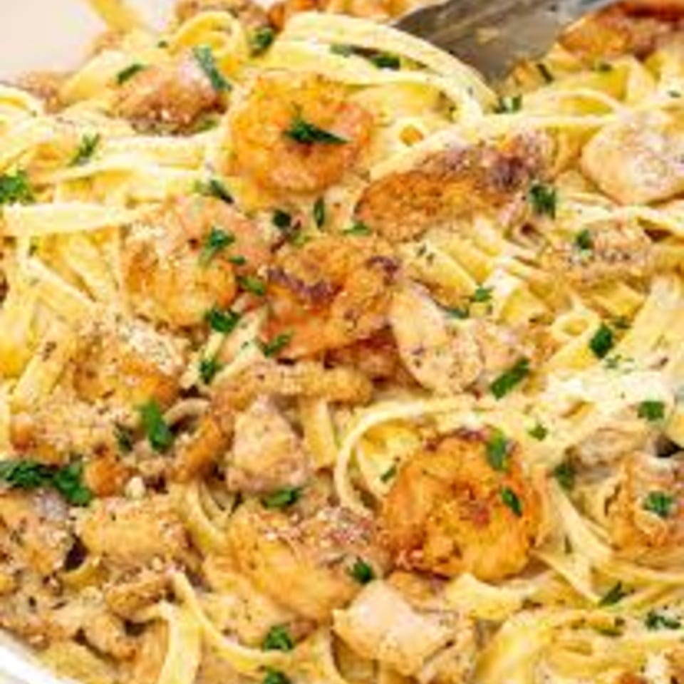 Creamy fettuccine pasta with grilled chicken, shrimp, and parsley, from Kings Roadhouse Bar & Grill.