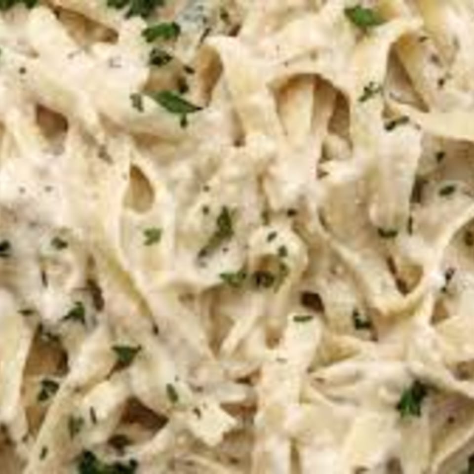Creamy fettuccine alfredo pasta with chopped parsley, a classic American dish from Kings Roadhouse.