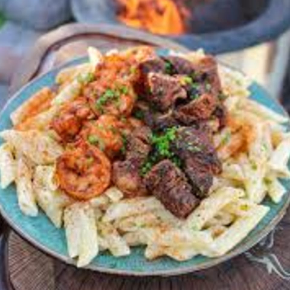 Kings Roadhouse Bar & Grill's pasta dish with grilled shrimp and steak, garnished with parsley.